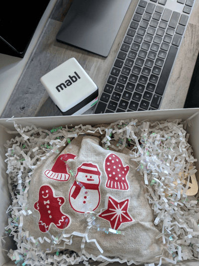 A Christmas present on a desk with a keyboard and a mabl cube.